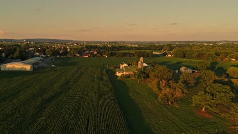 Eine-Luftaufnahme-Von-Amish-Farmen-Und-Feldern-Während-Der-Goldenen-Stunde-An-Einem-Spätsommernachmittag