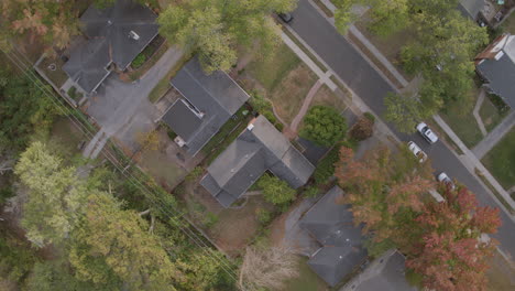 overhead aerial view of suburban houses and neighborhood street with a spin as a car drives through