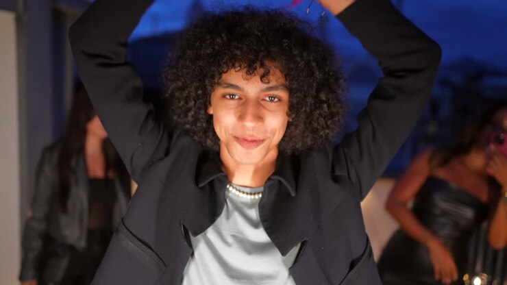 Young Man with Curly Hair and Pearl Necklace at a Night Party