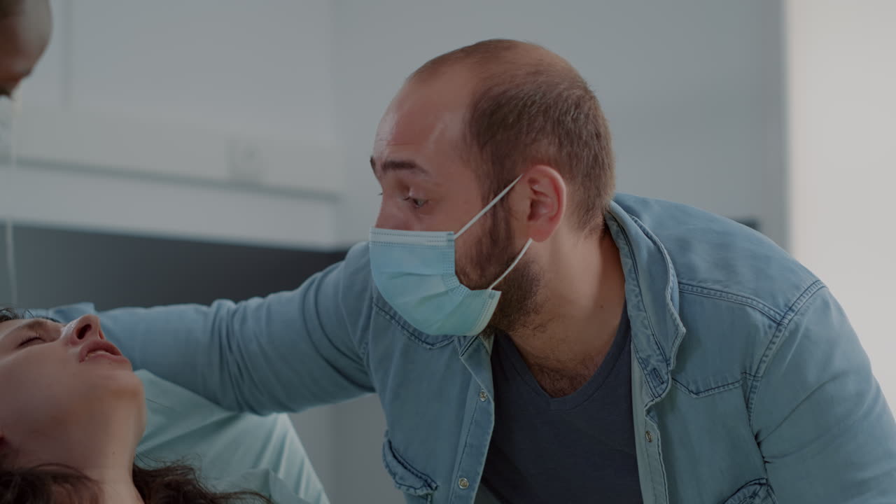 African american nurse helping with childbirth in hospital ward