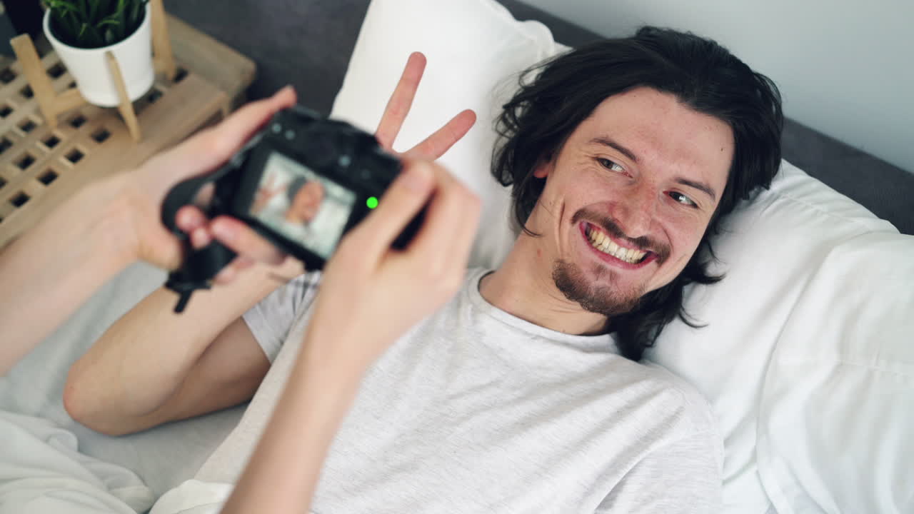 Couple taking photos in bed