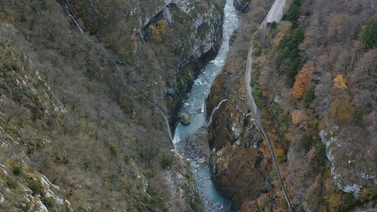 vista aérea de drones de arriba hacia abajo de la corriente de agua que fluye a lo largo de un barranco rocoso en bosques de montaña