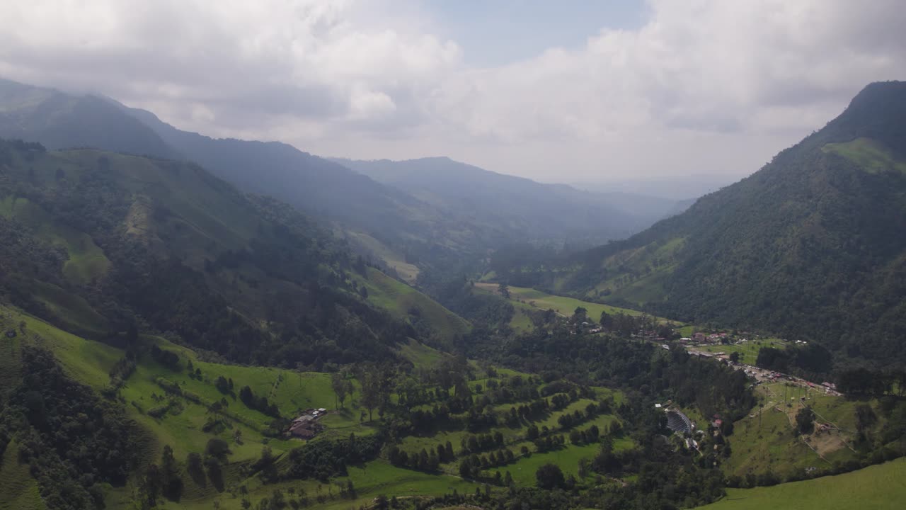 Panoramica aerea di un'ampia valle e di un fiume profondo sotto un cielo nuvoloso