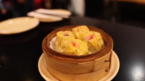 dumplings served in a bamboo basket on table