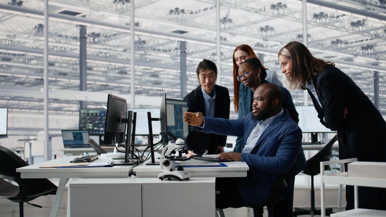 Diverse Team of Business Professionals Collaborating on Computer in Modern Office