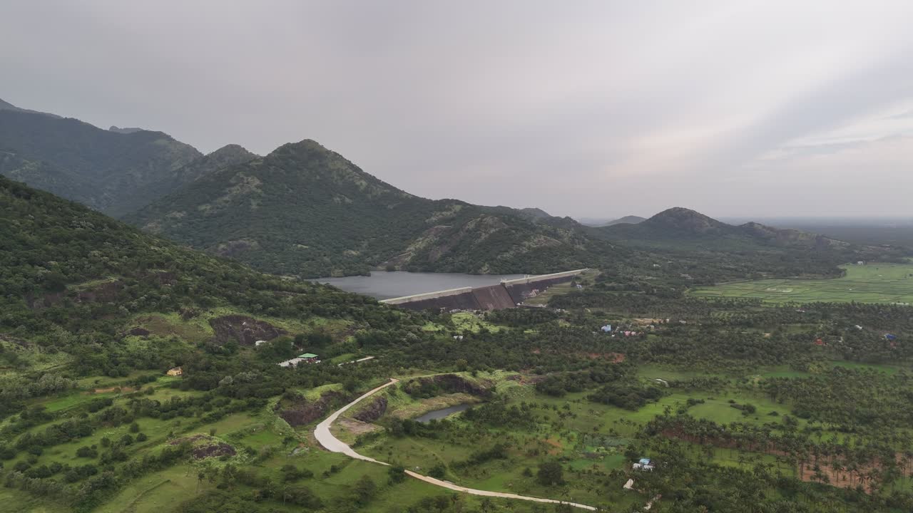 Beautiful drone shot of a dam and reservoir in the Western Ghats near Tenkasi, Tamil Nadu, with rolling hills, greenery, and peaceful natural scenery