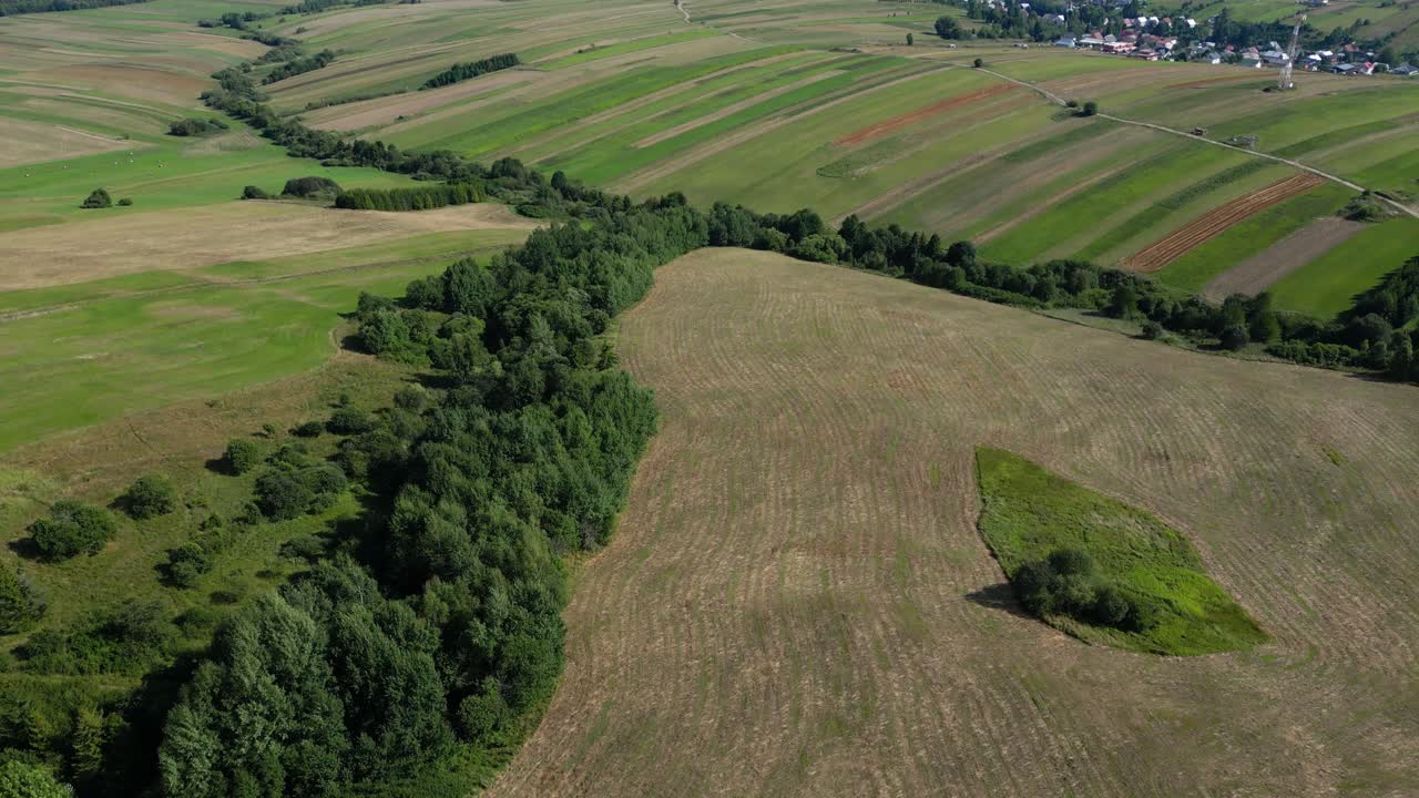 Slow cinematic drone tilt up over rolling fields in natural scenery in Europe
