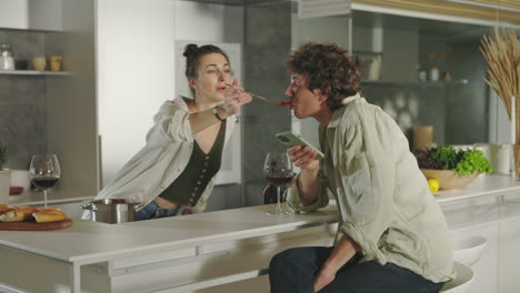 couple's playful food tasting in a modern kitchen