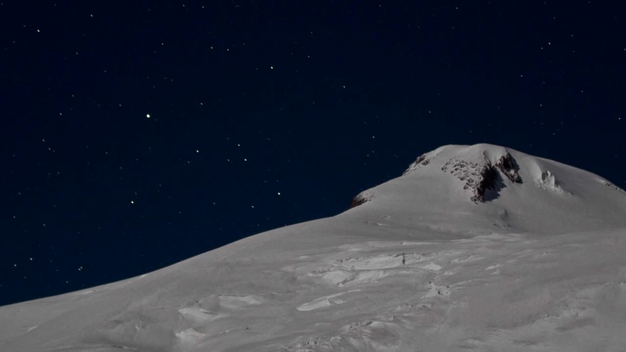 Primo piano della vetta con le stelle dietro di essa.