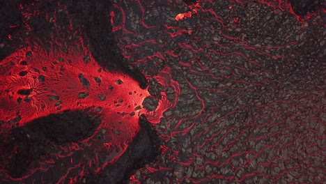 aerial rising top view of a lava river flowing across meradalir valley, iceland, erupting out of fagradalsfjall volcano