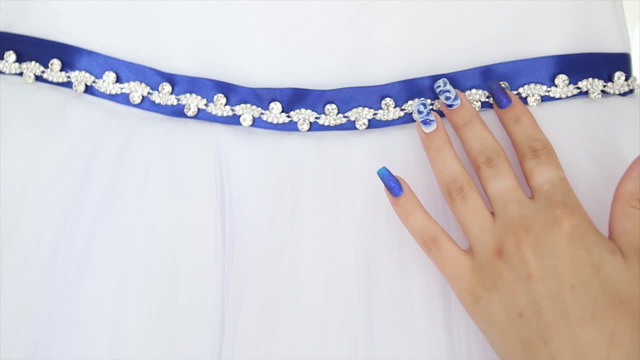 파란색으로 장식 된 벨트와 손으로  드레스