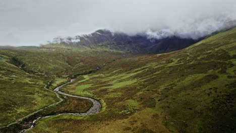 Dark-Clouds-Roll-Down-Mountain-Side-Into-Fairytale-Landscape-In-Skye,-Scotland