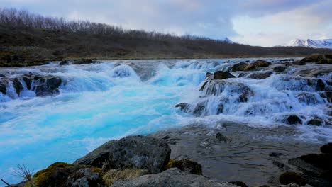 ice-blue colored water flooding cascade waterfall and stream during daytime