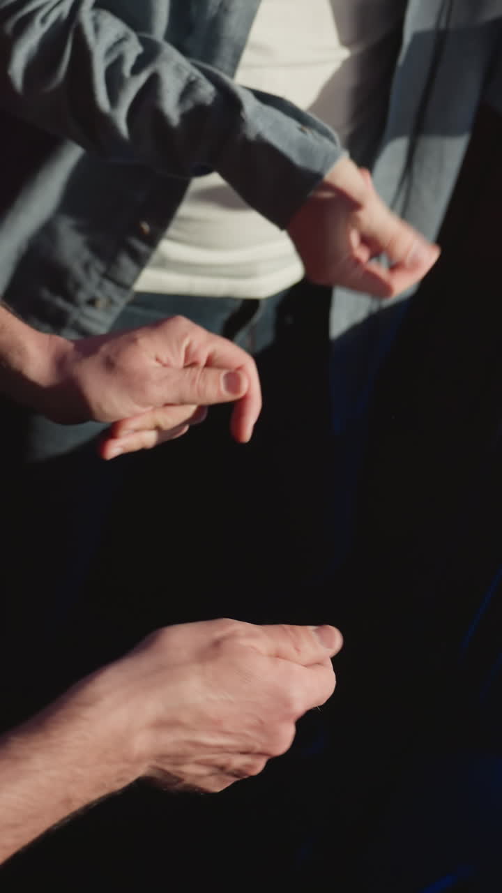 녹음 스튜디오에서 두 남자가 손가락을 리하게 는 클로즈업, 그들의 손과 캐주얼 의상에 초점을 맞추고, 스튜디오 장비와 녹색 led 조명과 함께 창의적인 분위기