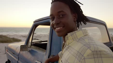 Man-looking-at-camera-near-pickup-truck-at-beach-4k