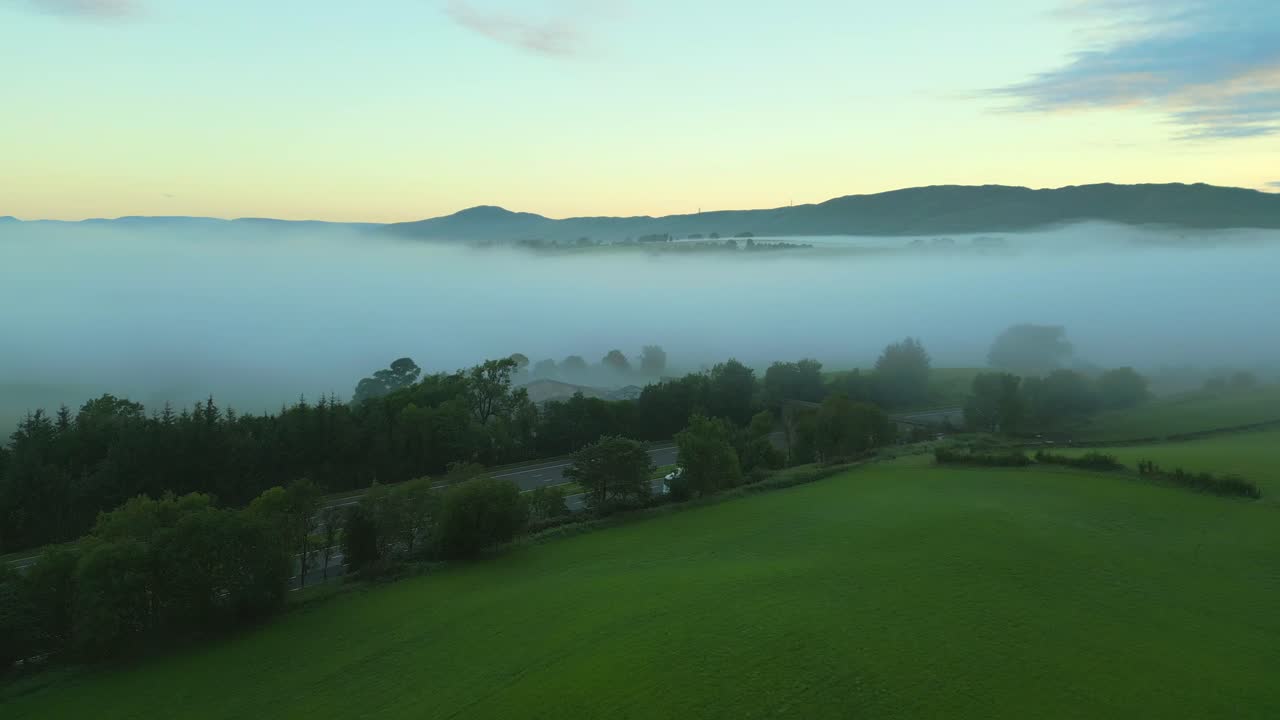 초록 과 m6 고속도로 위를 날아가며 안개와 안개 과 먼 언덕과 산을 향해 새벽에