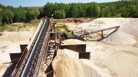 Montículos-De-Arena-Y-Una-Cinta-Transportadora-En-Una-Antigua-Cantera-De-Arena-Cerca-De-Prudnik,-Polonia---Drone-Volando-Hacia-Adelante