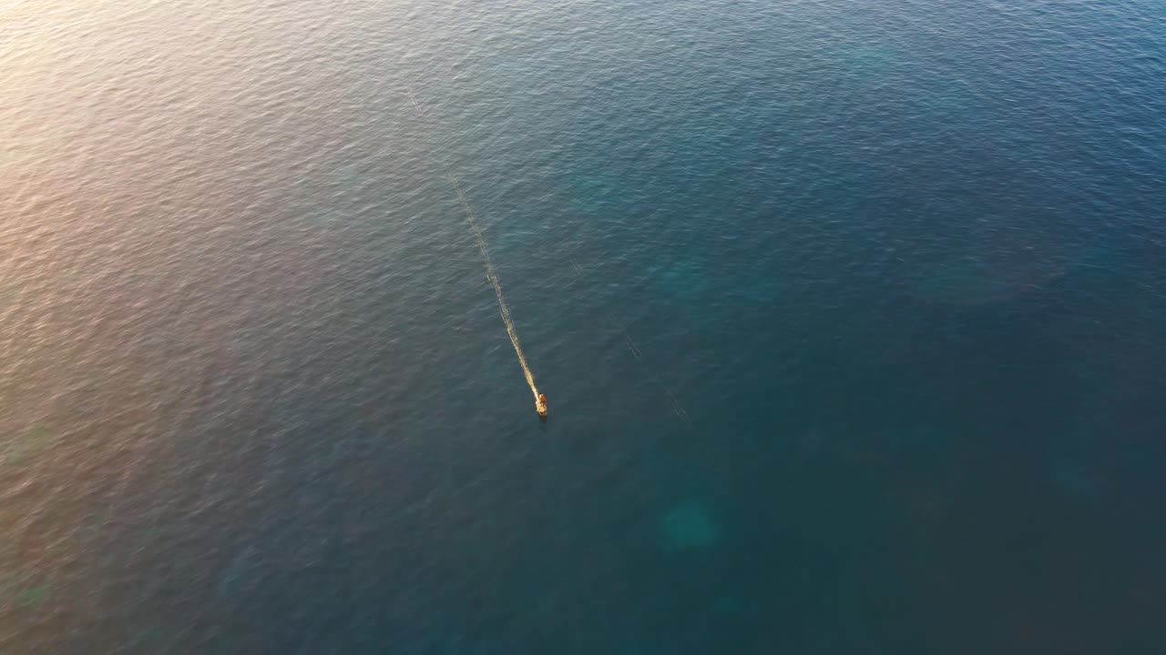 전기 서핑보드를 타고 칼라 에스콘디다 해안선에서 바다를 가로질러 서핑하는 사람의 조감도