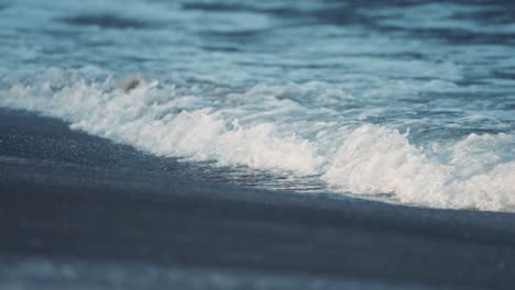 waves break around the sandy beach in ersfjord