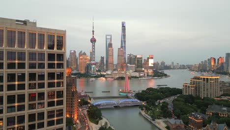 lights shine up along iconic shanghai buildings along huangpu river near the bund