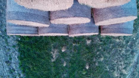 las balas de heno, apiladas en una pirámide, secas en el campo al atardecer.