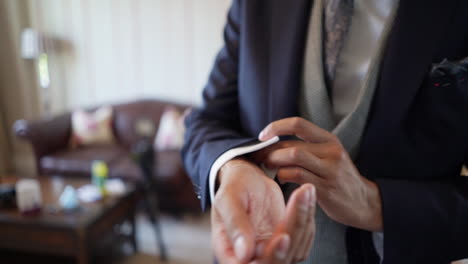 a closeup view of a man in suit button up his coat