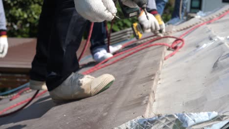 asian worker doing roof tiles installation, cutting, measuring process, close up