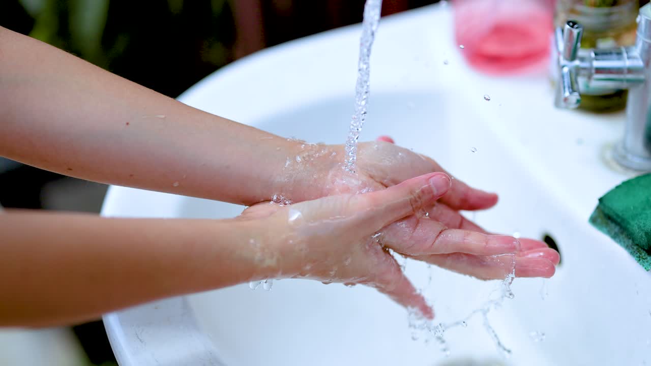 Person washing hands under running water