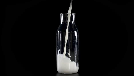 milk gradually fills a clear glass bottle