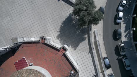 people stroll on the historic sidewalks of lisbon near a chapel in the heart of the city