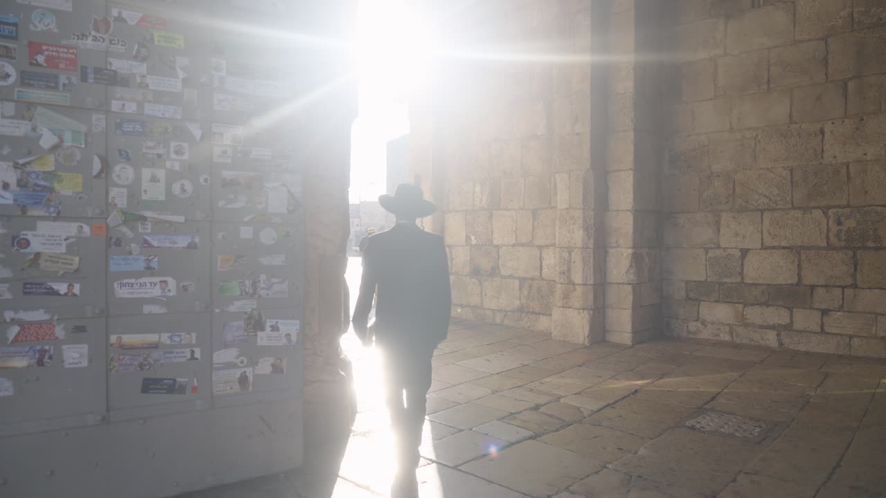 정교회 유대인 남자가 예루살렘의 오래된 도시 야파 게이트를 걸어가고 있다.