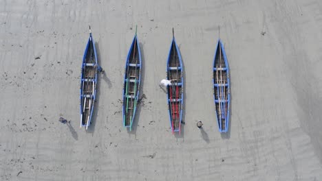 top down bird's eye view aerial of traditional irish boats, currachs on sandy beach