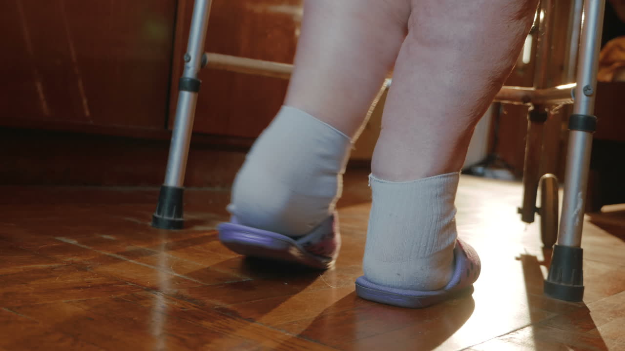 집 안을 돌아다니기 위해 노력하는 고령 여성