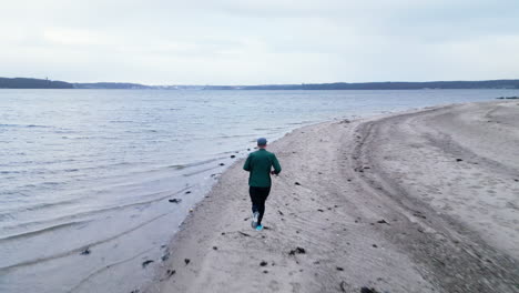 Läufer-Am-Ruhigen-Winterstrand-In-Der-Abenddämmerung