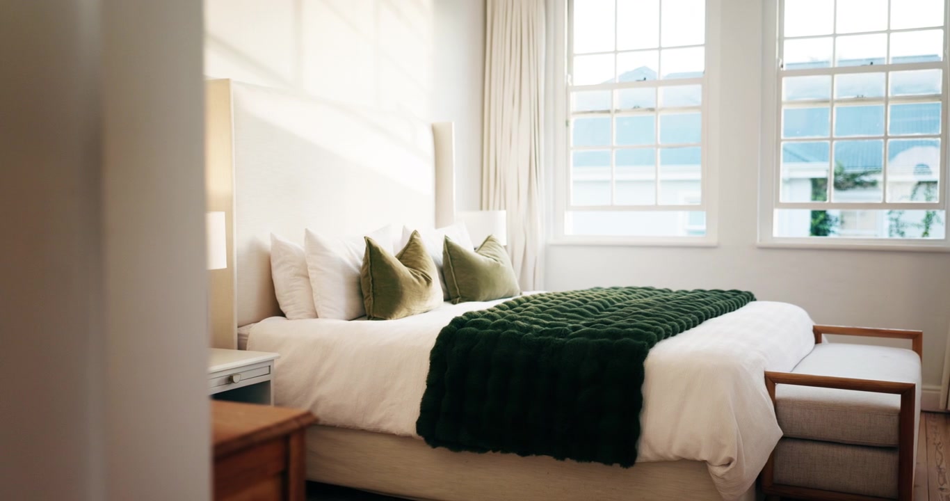 Interno di camera da letto moderna con plaid verde e luce naturale