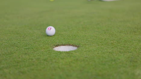 golf ball near the hole on the putting green