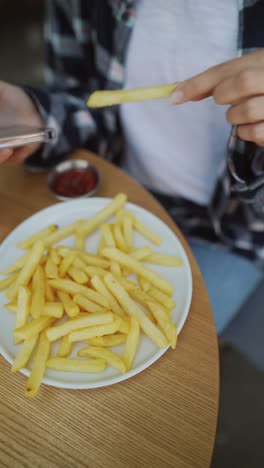 woman eating french fries at a cafe