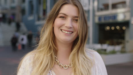 retrato de una joven rubia feliz que se quita las gafas de sol sonriendo alegremente disfrutando de los viajes urbanos