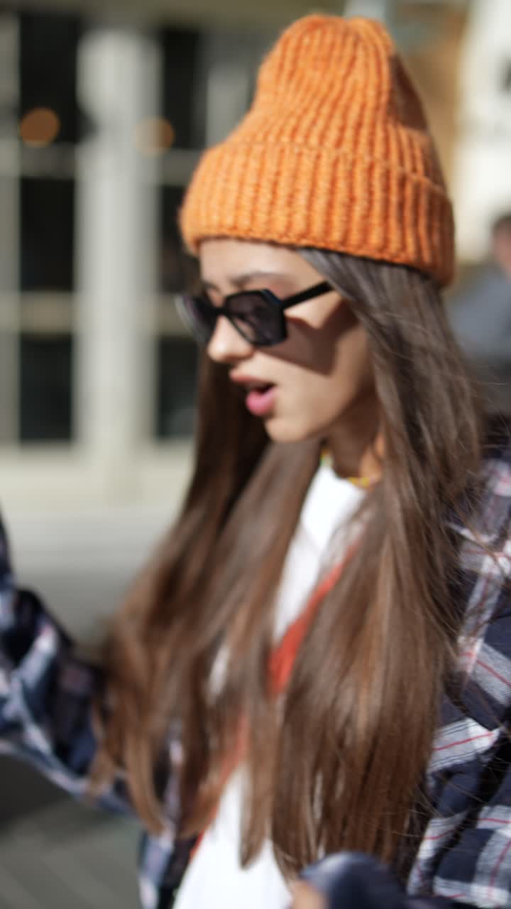 mujer elegante con un sombrero de punto naranja y una camisa a cuadros