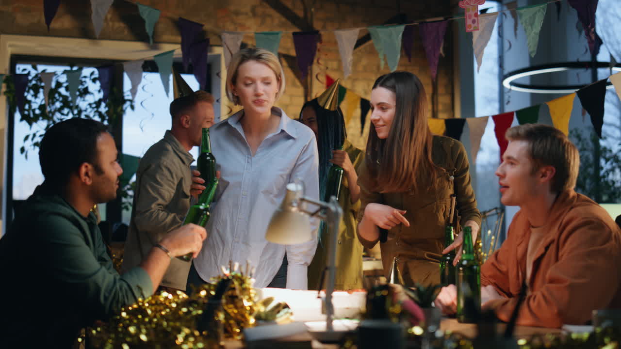 colegas relajados hablando fiesta de cumpleaños sosteniendo cerveza. equipo disfrutando de la reunión