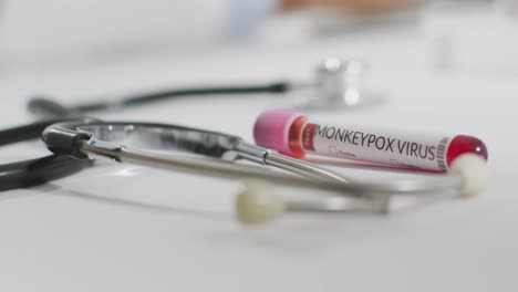 Close-up-of-vials-with-monkeypox-virus-and-stethoscope