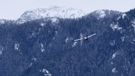 sea plane flying towards mountains in wintertime