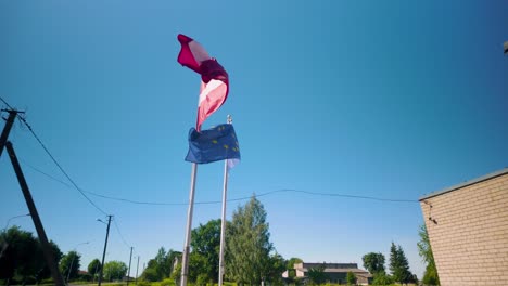 Zeitlupenaufnahmen-Der-Lettischen-Und-Der-Europäischen-Union-Flaggen,-Die-An-Einem-Sonnigen-Tag-Sanft-Im-Wind-Wehen