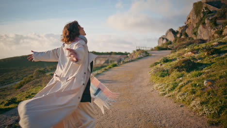 happy explorer walking cliffside radiating joy and freedom in scenic outdoors.