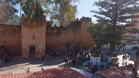 view overlooking people walking past the kasbah, place outa el hamam, located at chefchaouen, morocco