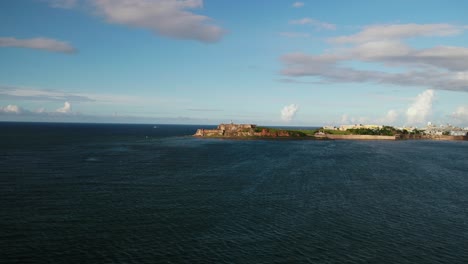 Zumbido-Cerca-De-Cabras-Sobre-La-Bahia-De-San-Juan-Con-Los-Morillos-Al-Fondo