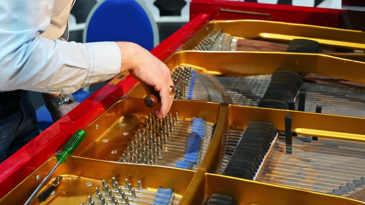 Close up of a man fixing a red piano
