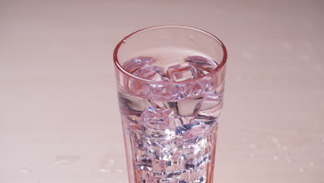 sparkling water glass falling ice cube