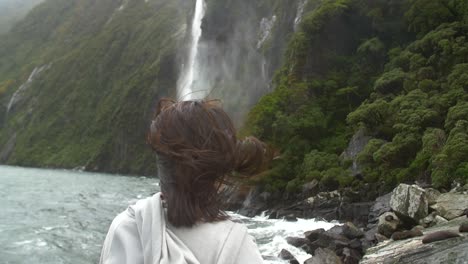 panning around woman watching waterfall