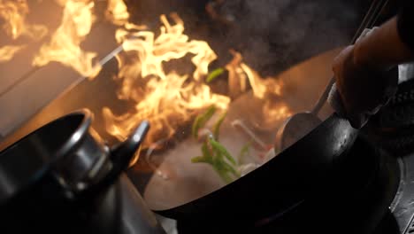 stir frying sea food and vegetables on a fiery wok asian cuisine slow-mo 4k